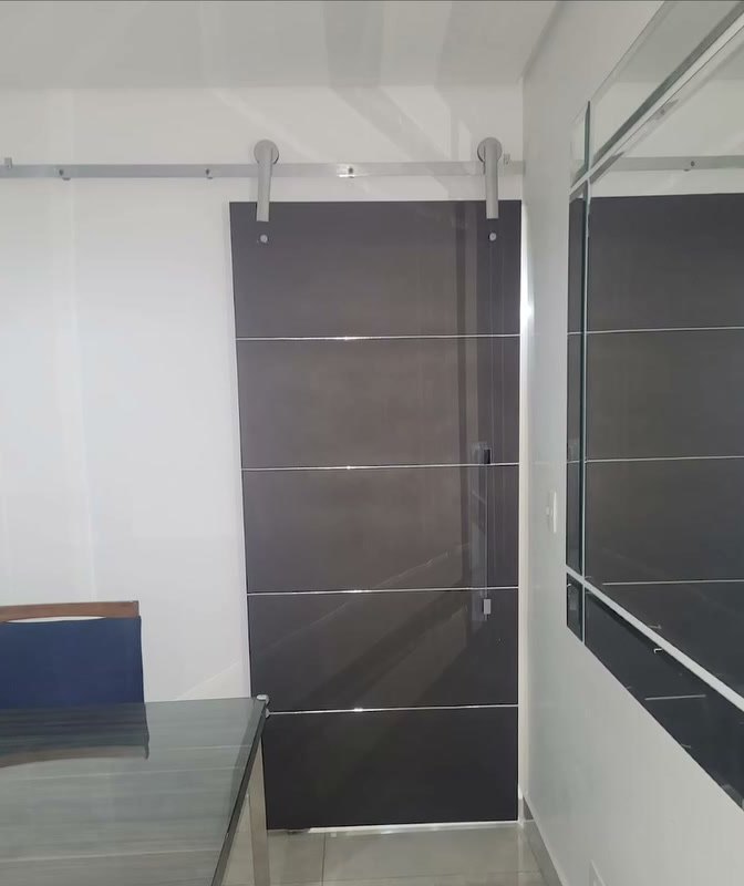 Sala de jantar com porta de correr escura e espelho