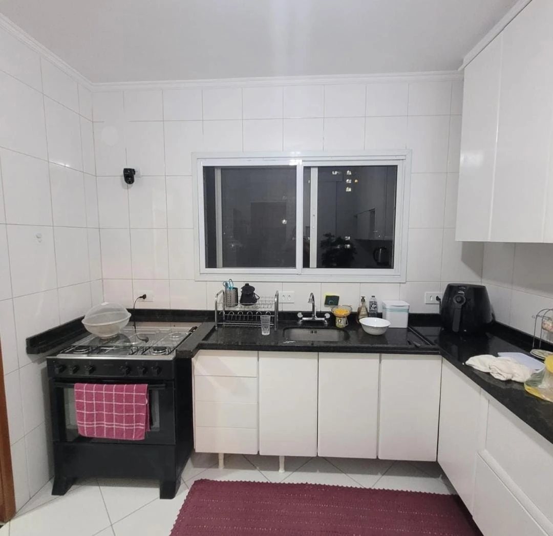 Antes: cozinha com azulejo branco, granito preto e armários brancos