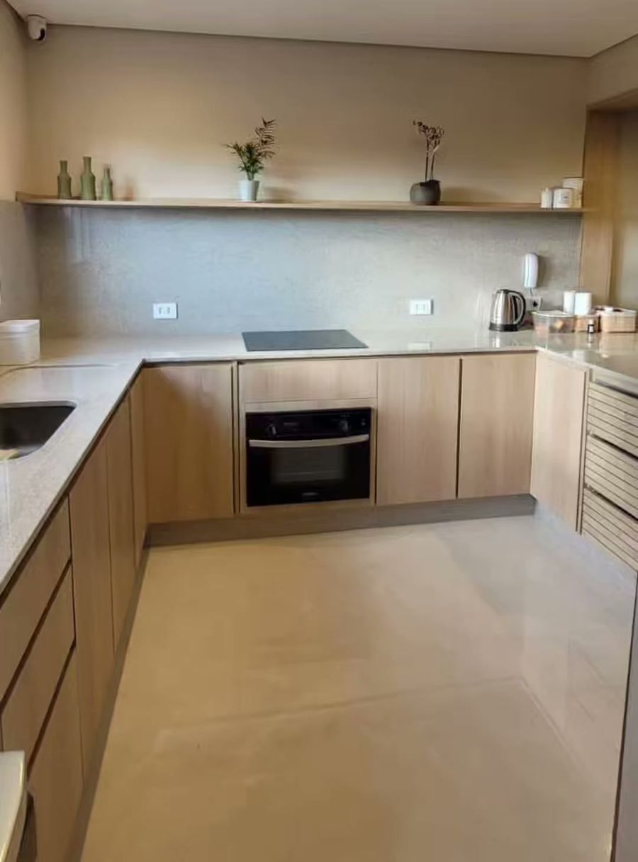 Cozinha com armários de madeira clara e cooktop de indução