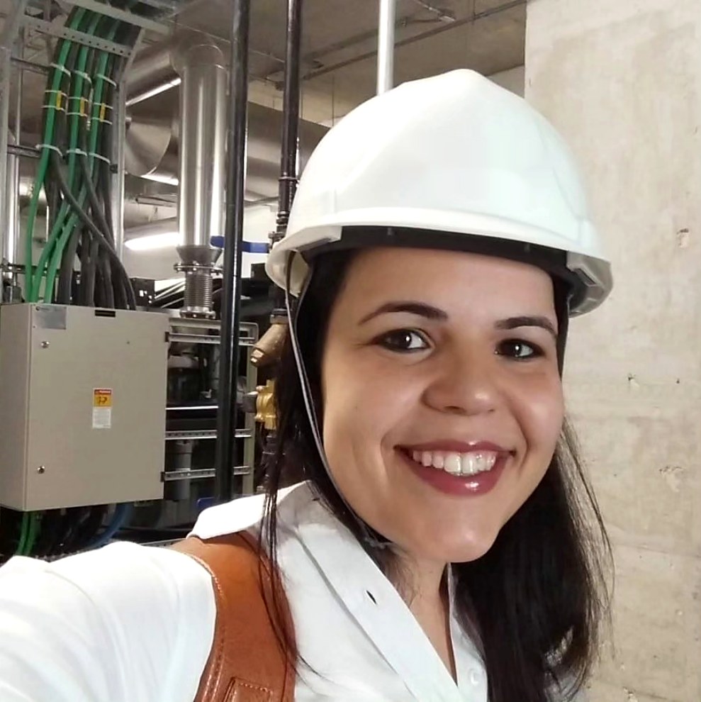 Nathália Marin, engenheira civil da Realizando Engenharia, sorrindo, com capacete de segurança branco em uma obra