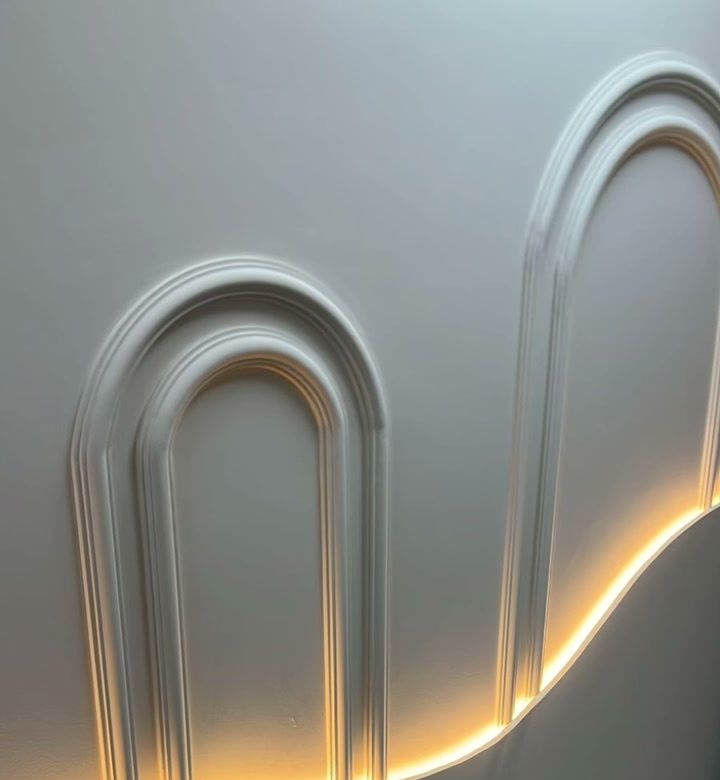 Parede com molduras em arco e iluminação em LED em um projeto comercial