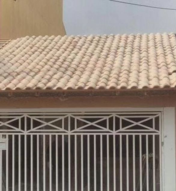 Telhado de telhas cerâmicas sobre portão de residência
